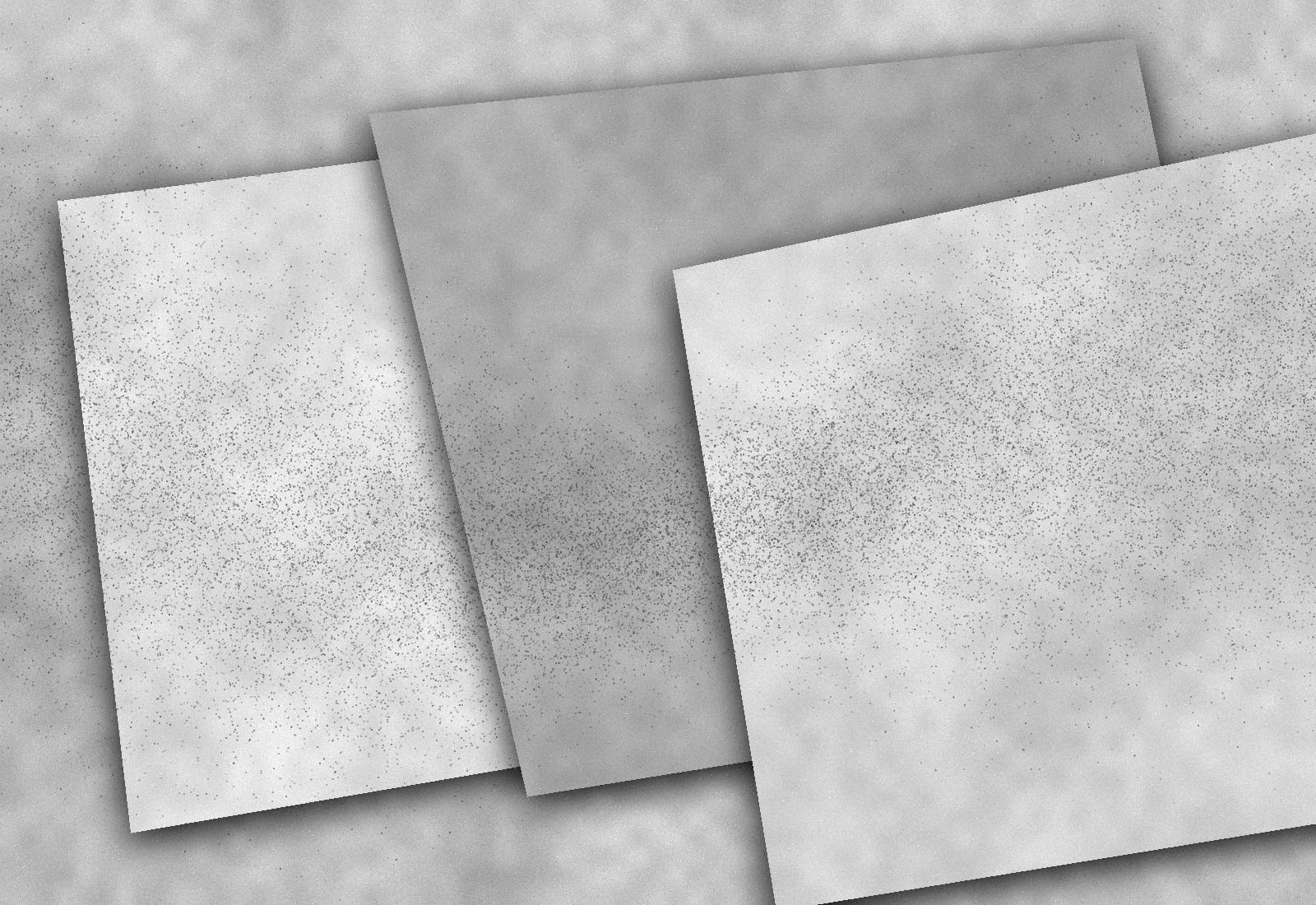 Three layered paper proofs crossed by a changing field of ink grains
